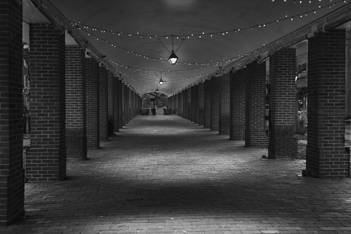 Black and white view of covered marketplace at night.